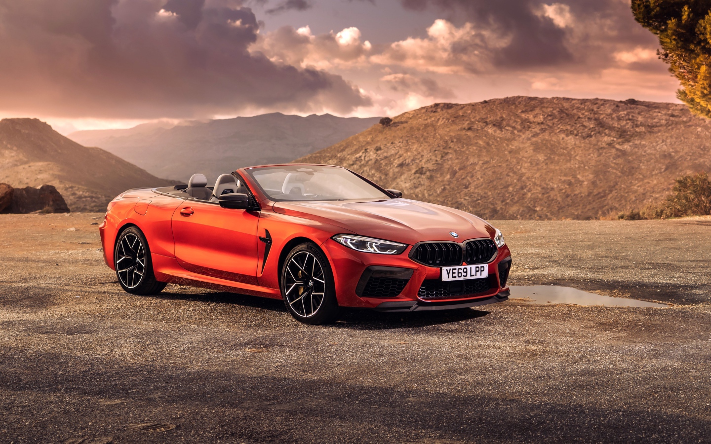 Красный кабриолет BMW M8, 2019 года у гор