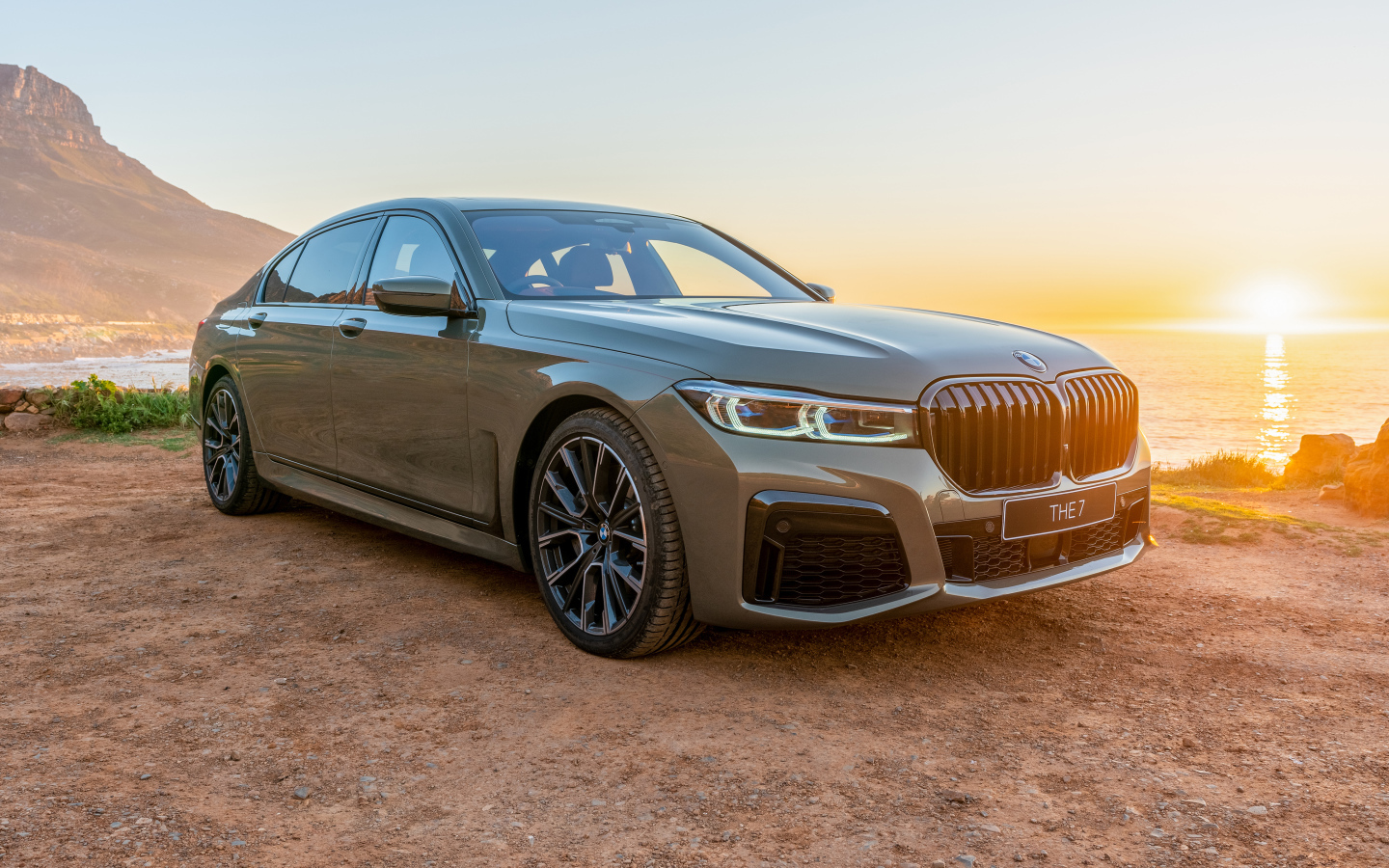 Стильный дорогой автомобиль BMW 745Le , 2020 года на фоне заката