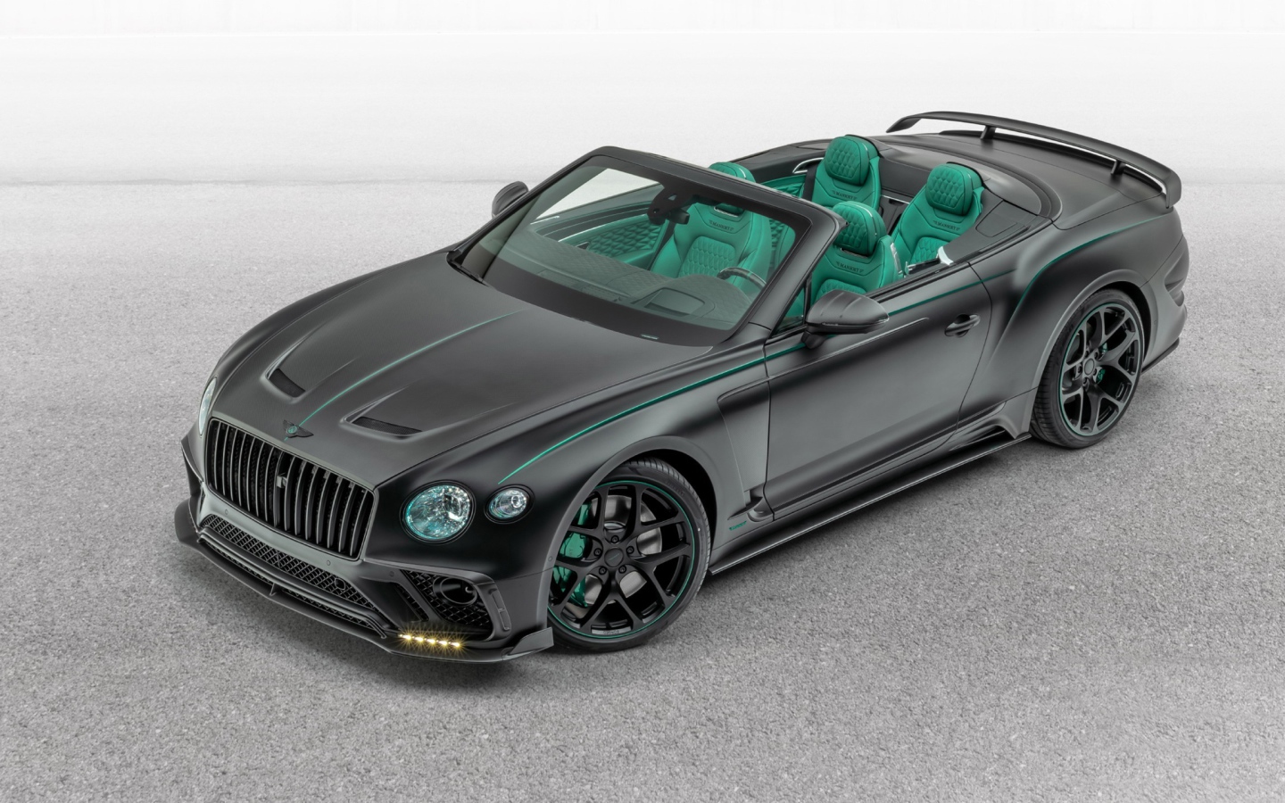 Черный автомобиль Mansory Bentley Continental GT V8 Convertible 2020 года на сером фоне