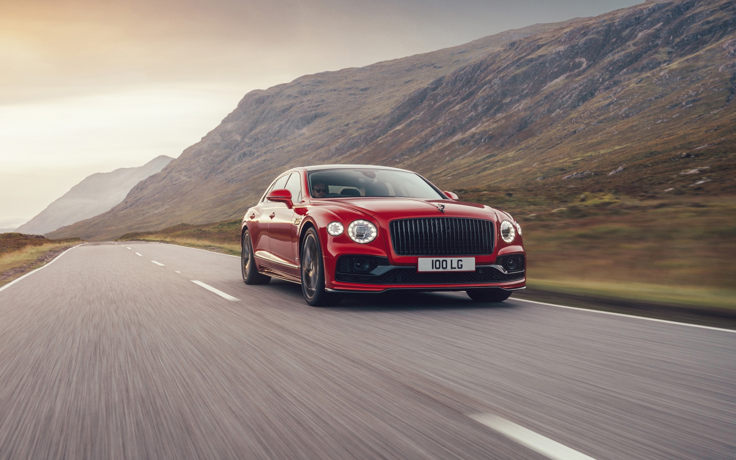 Красный автомобиль Bentley Flying Spur V8 2020 года на дороге  