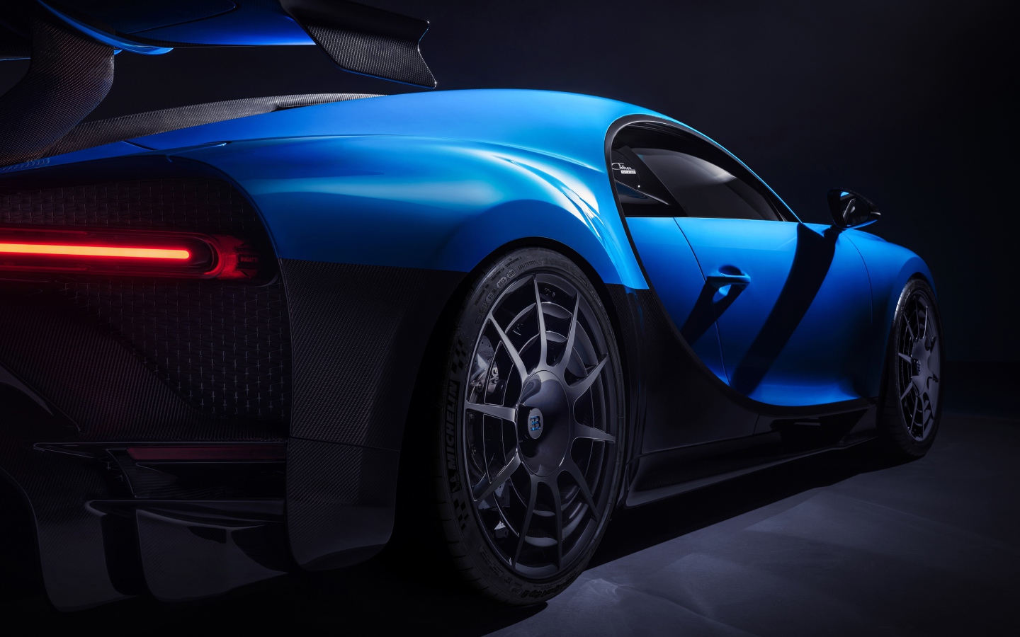 Автомобиль Bugatti Chiron Pur Sport 2020 года вид сзади на черном фоне