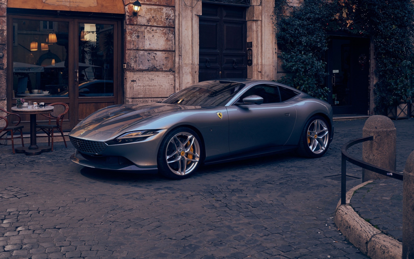 Серебристый автомобиль Ferrari Roma 2020 года у кафе