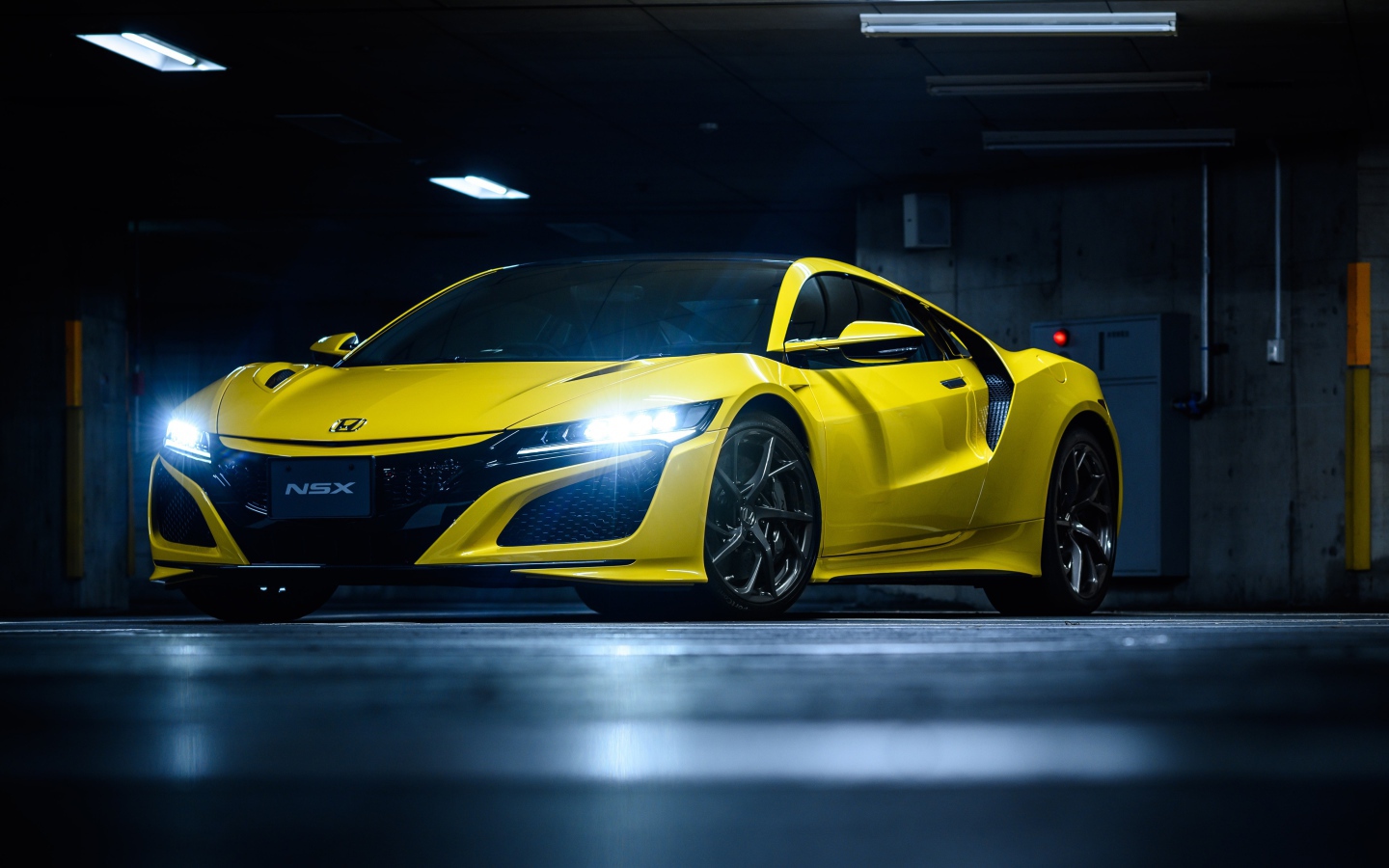 Желтый автомобиль Honda NSX с включенными фарами 