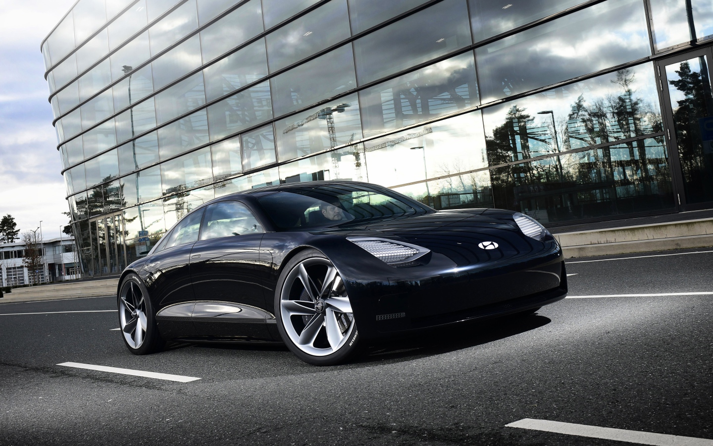 Черный автомобиль Hyundai Prophecy 2020 года у стеклянного здания 