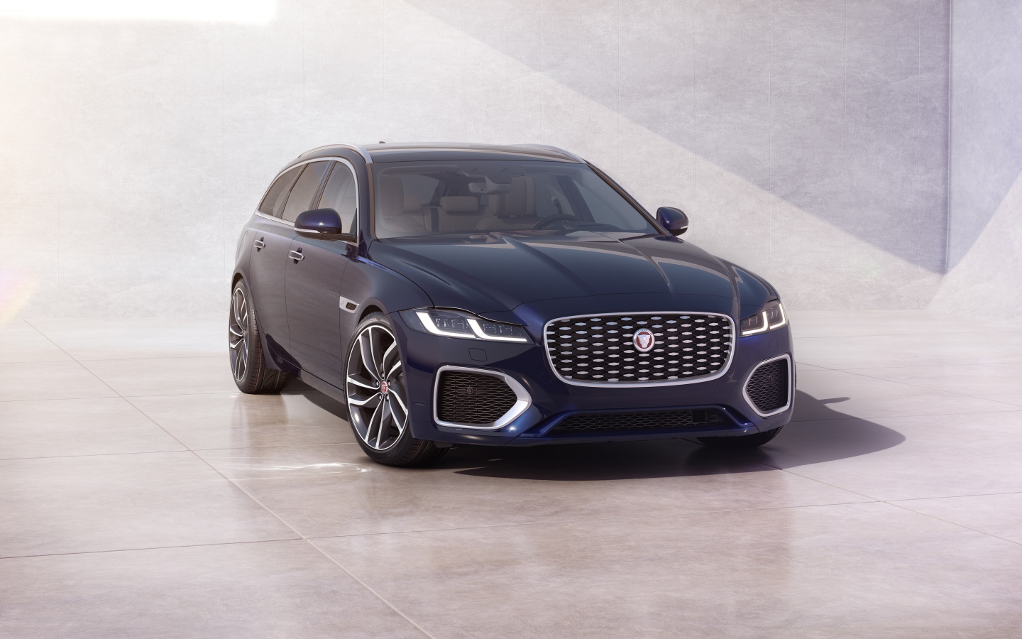 Синий автомобиль Jaguar XF Sportbrake 2020 года у стены 