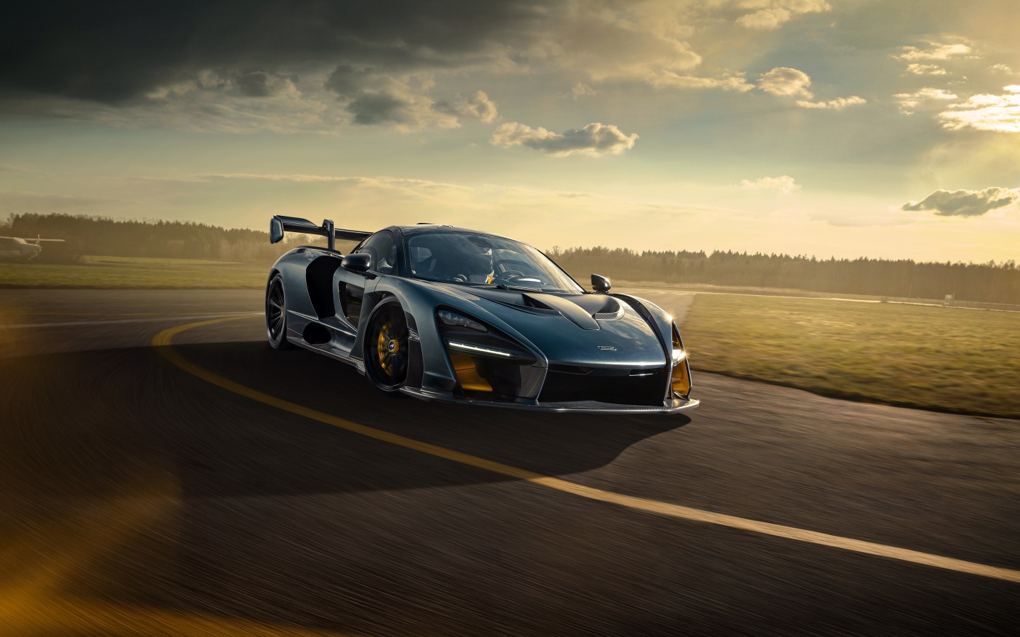 Гоночный автомобиль  McLaren Senna 2020 года на фоне заката 