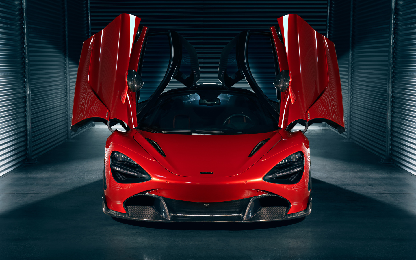 Красный автомобиль McLaren 720S с открытыми дверями в гараже