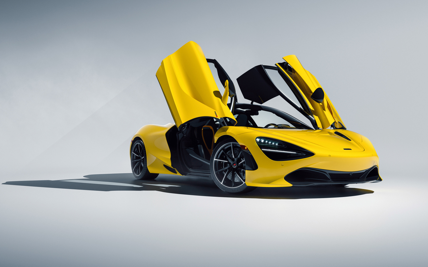 Желтый автомобиль McLaren 720S CGI с открытыми дверями на сером фоне