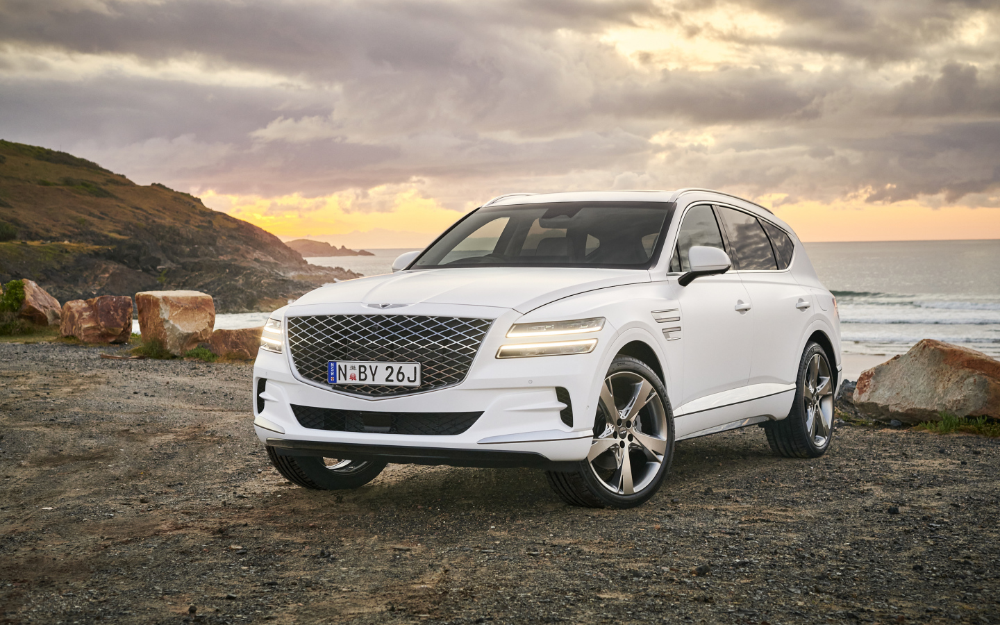 Белый автомобиль Genesis GV80 3.0D AWD 2020 года на фоне заката