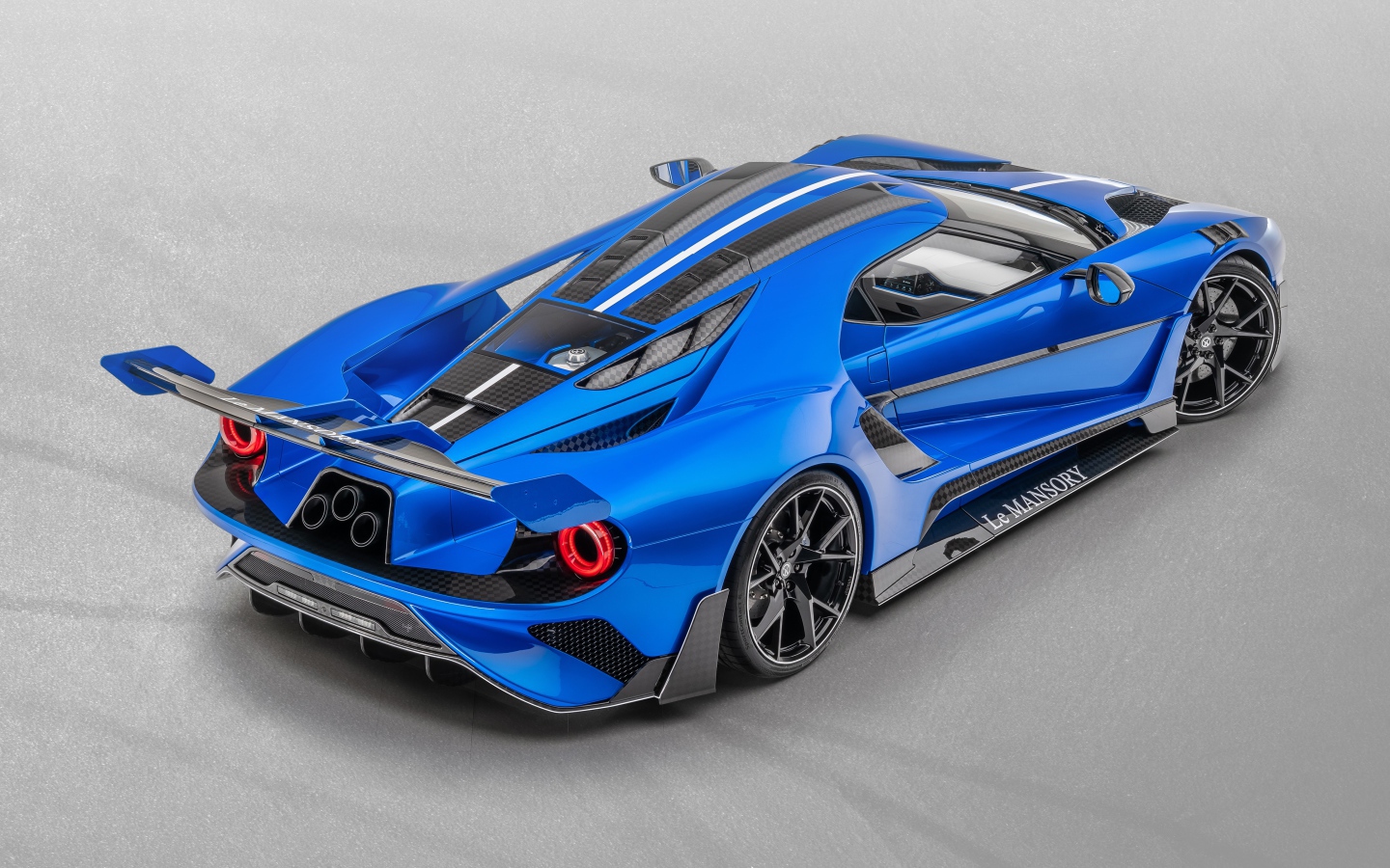 Синий автомобиль Mansory La MANSORY 2020 года на сером фоне вид сзади