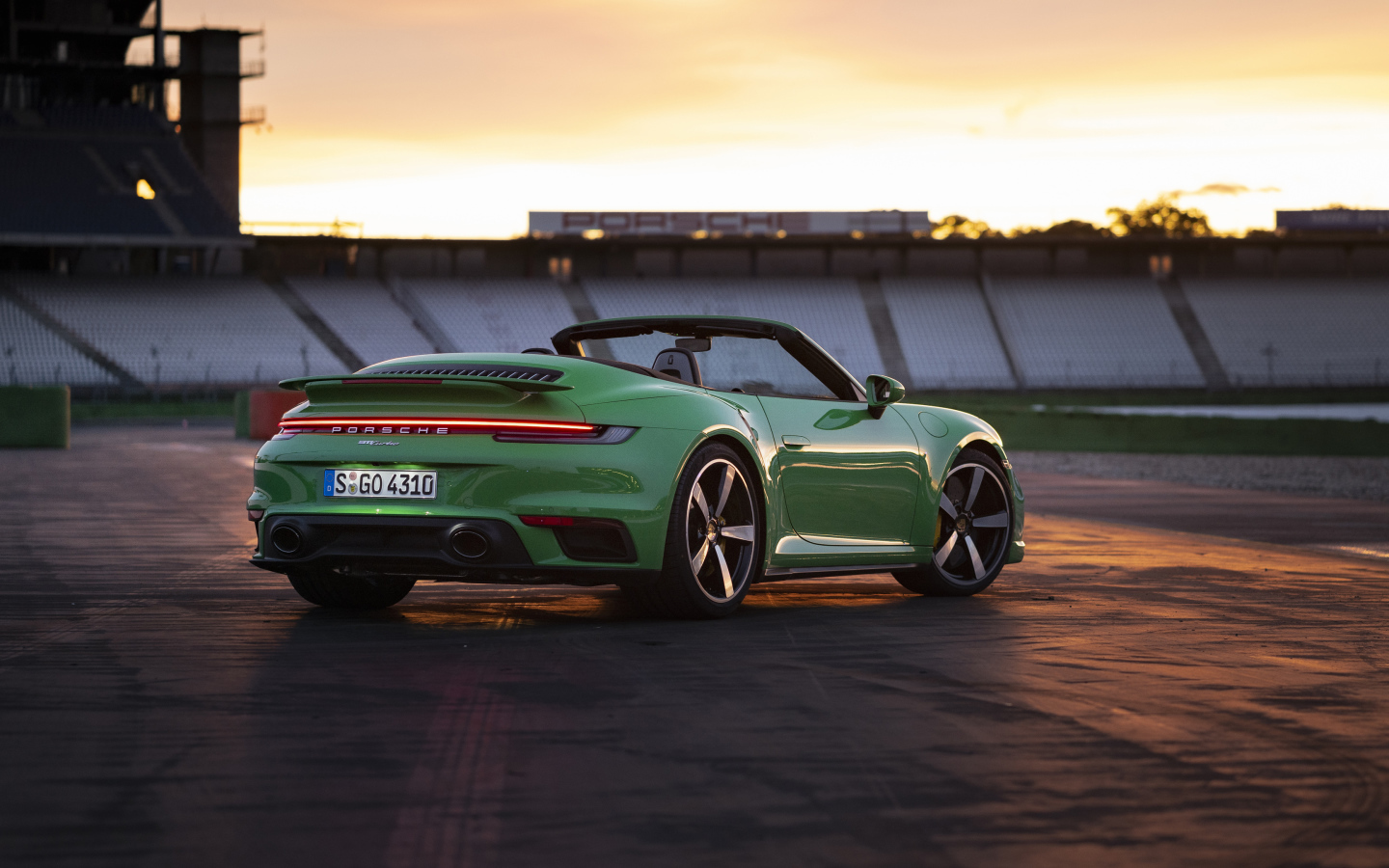 Зеленый автомобиль Porsche 911 Turbo Cabriolet 2020 года вид сзади