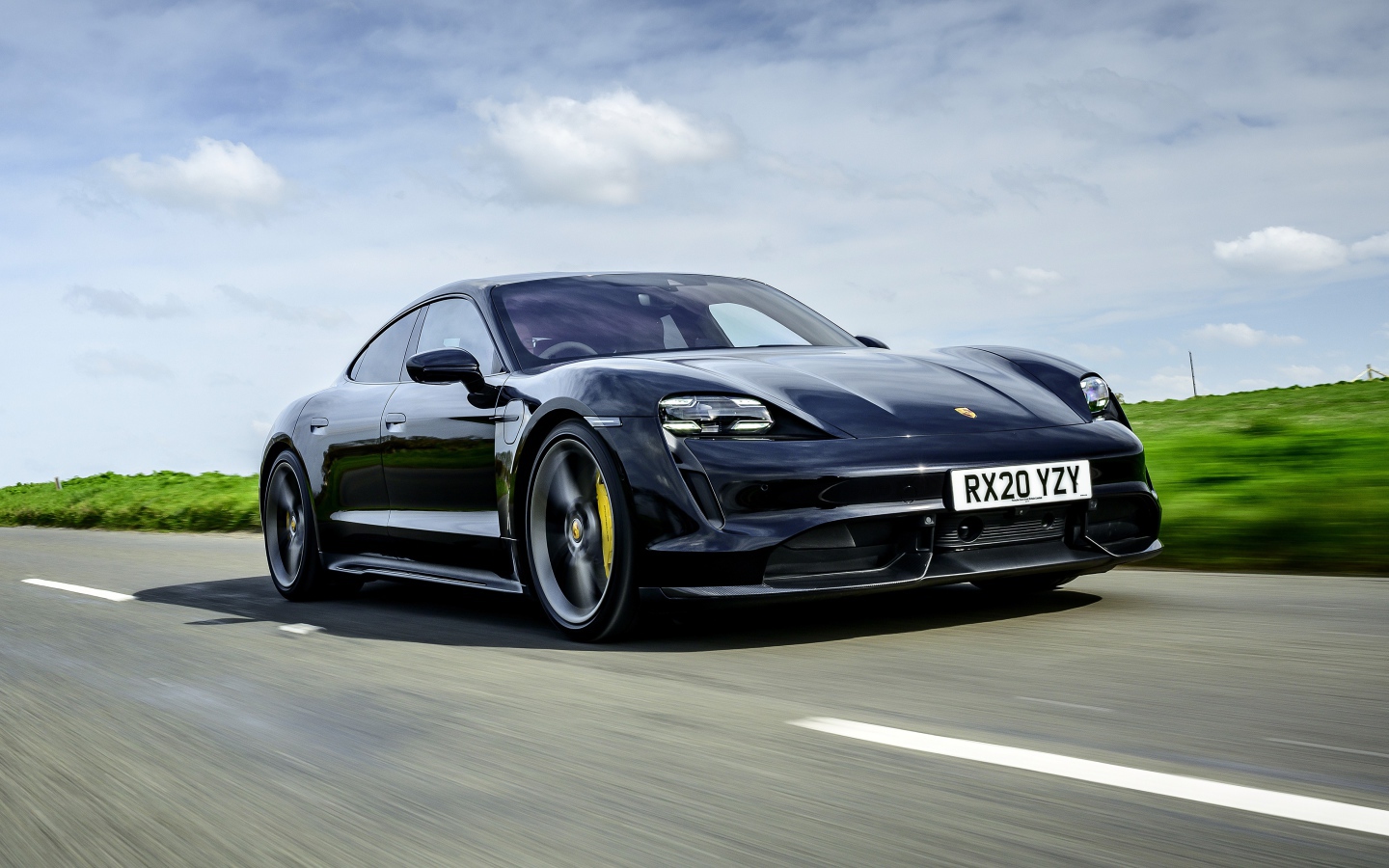 Черный автомобиль Porsche Taycan Turbo S 2020 года на скорости 