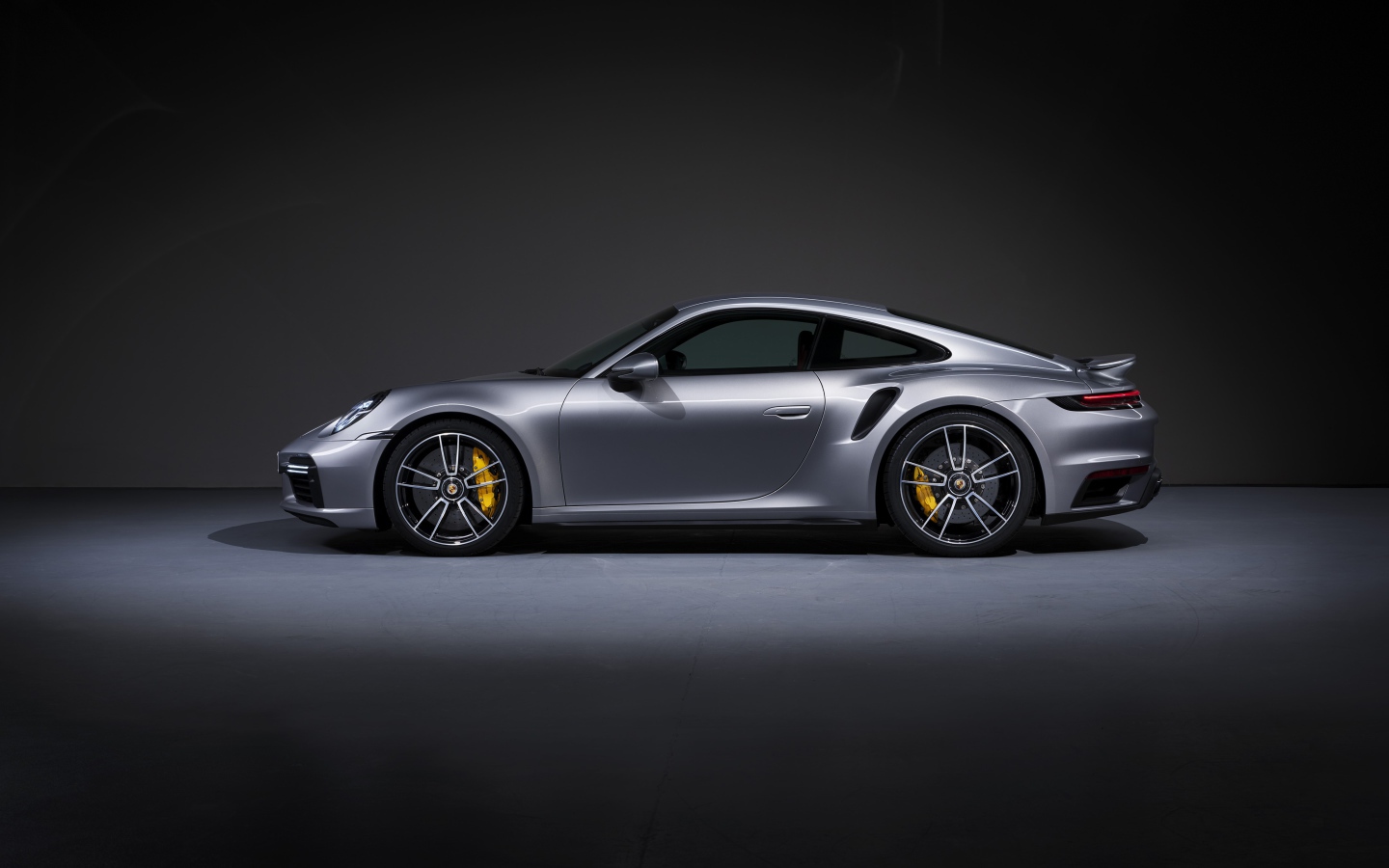 Серебристый автомобиль Porsche 911 Turbo S 2020 года вид сбоку 