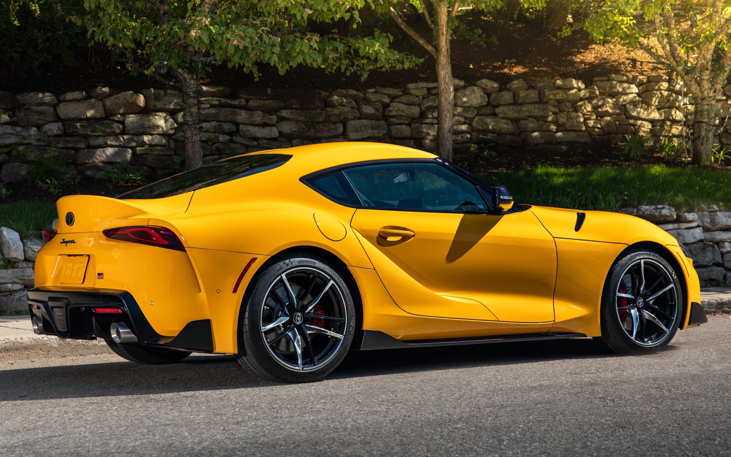 Желтый автомобиль Toyota GR Supra 2, 2021 года вид сбоку 