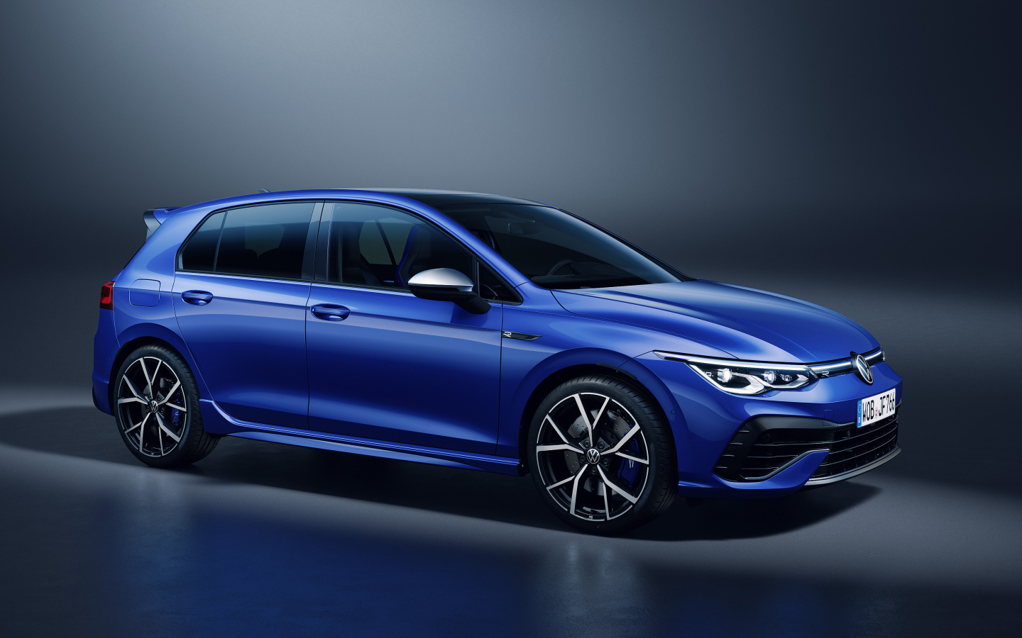 Синий автомобиль Volkswagen Golf R 2020 года на сером фоне