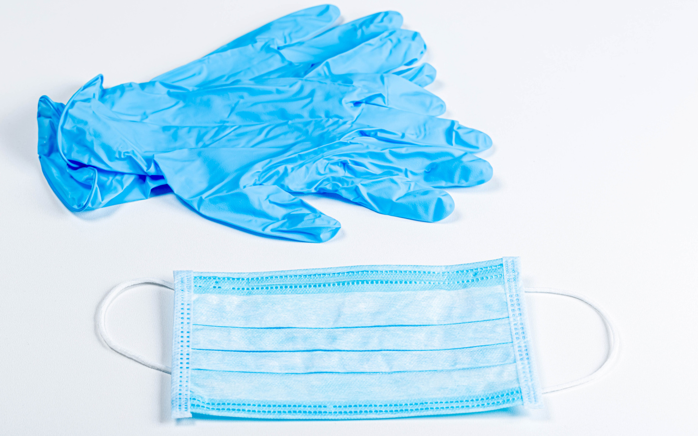 Синие перчатки и маска для лица на белом фоне от коронавируса 