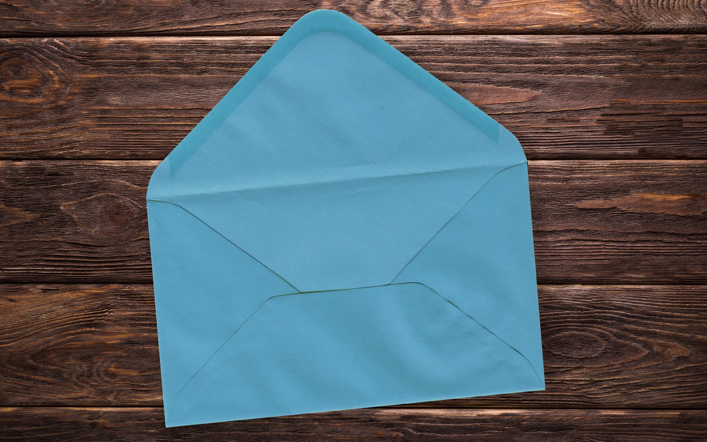 Голубой бумажный конверт на деревянном фоне