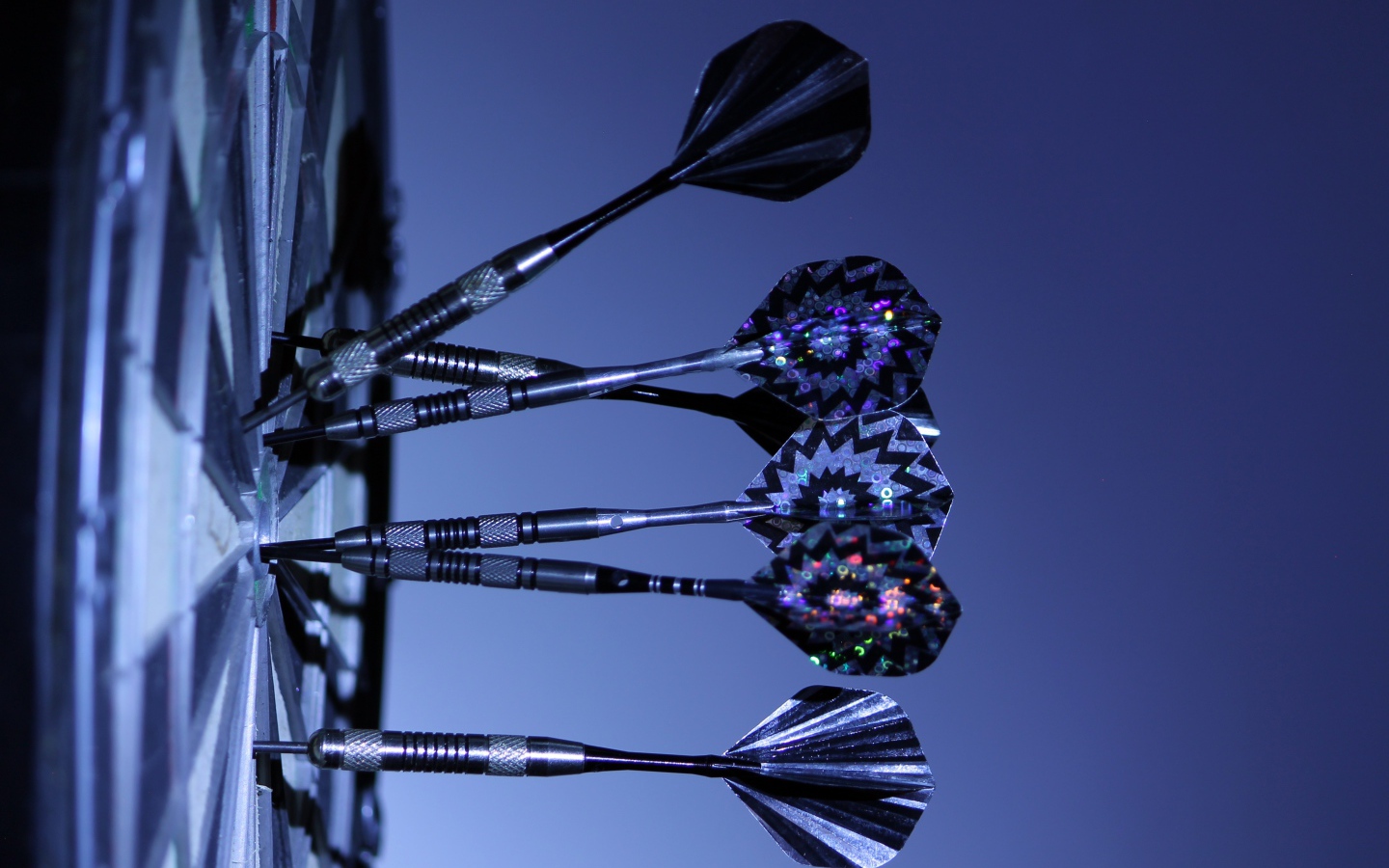 Дротики в доске для дартс на синем фоне 