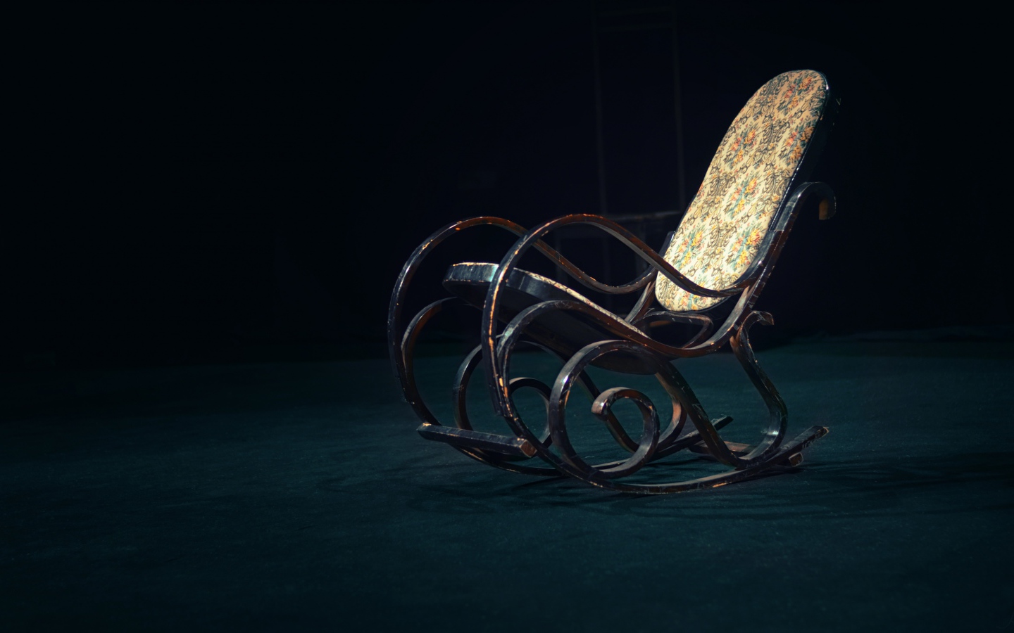 Старое кресло - качалка в темной комнате 