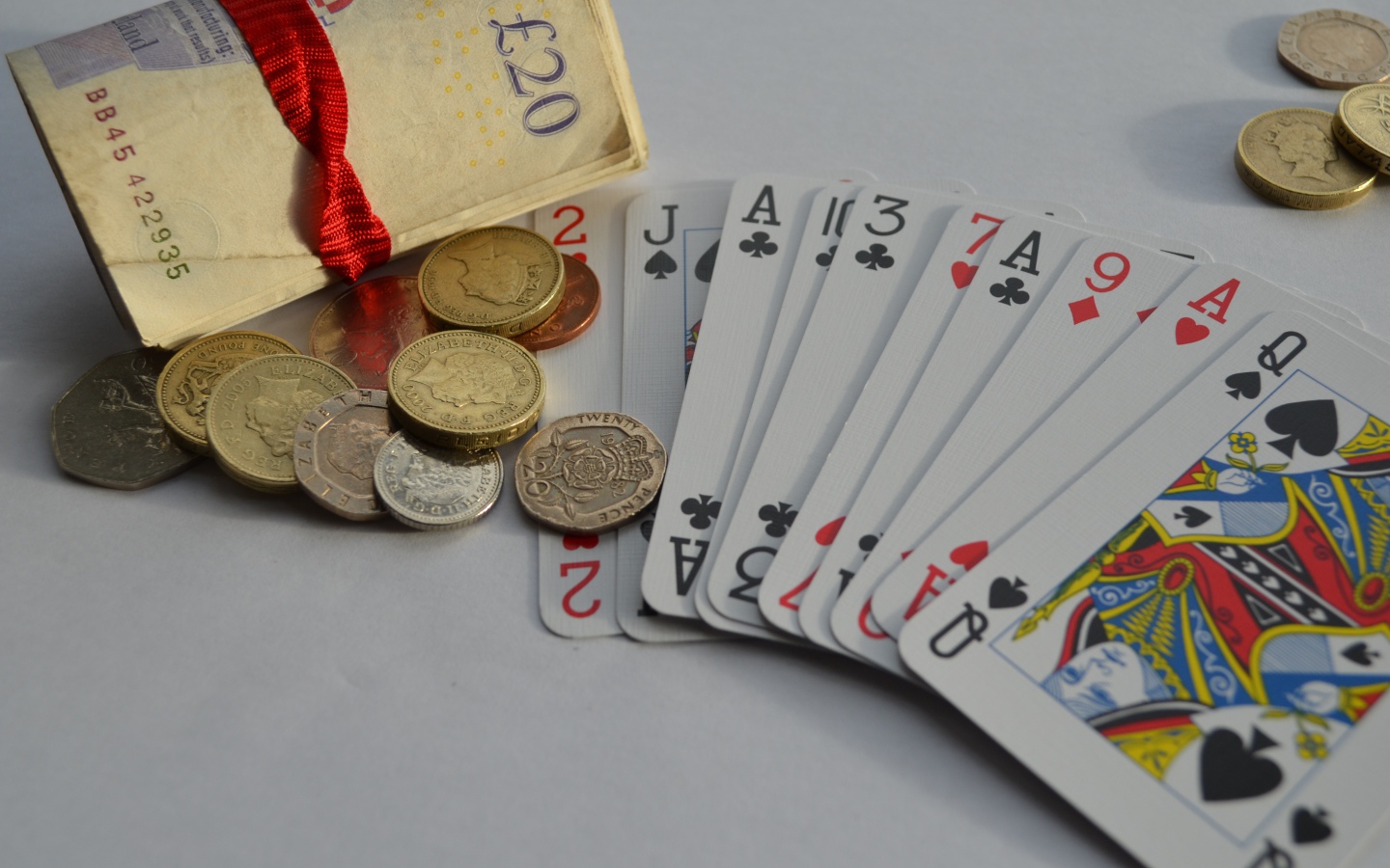 Деньги, монеты и колода карт на столе