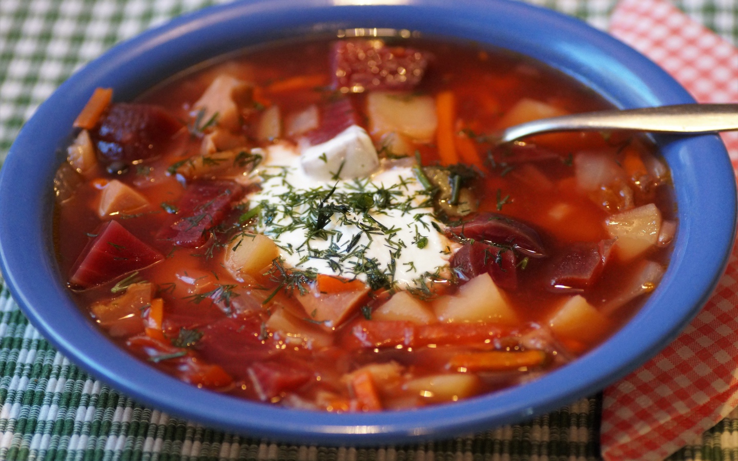 Borscht with sour cream in a blue bowl on the table