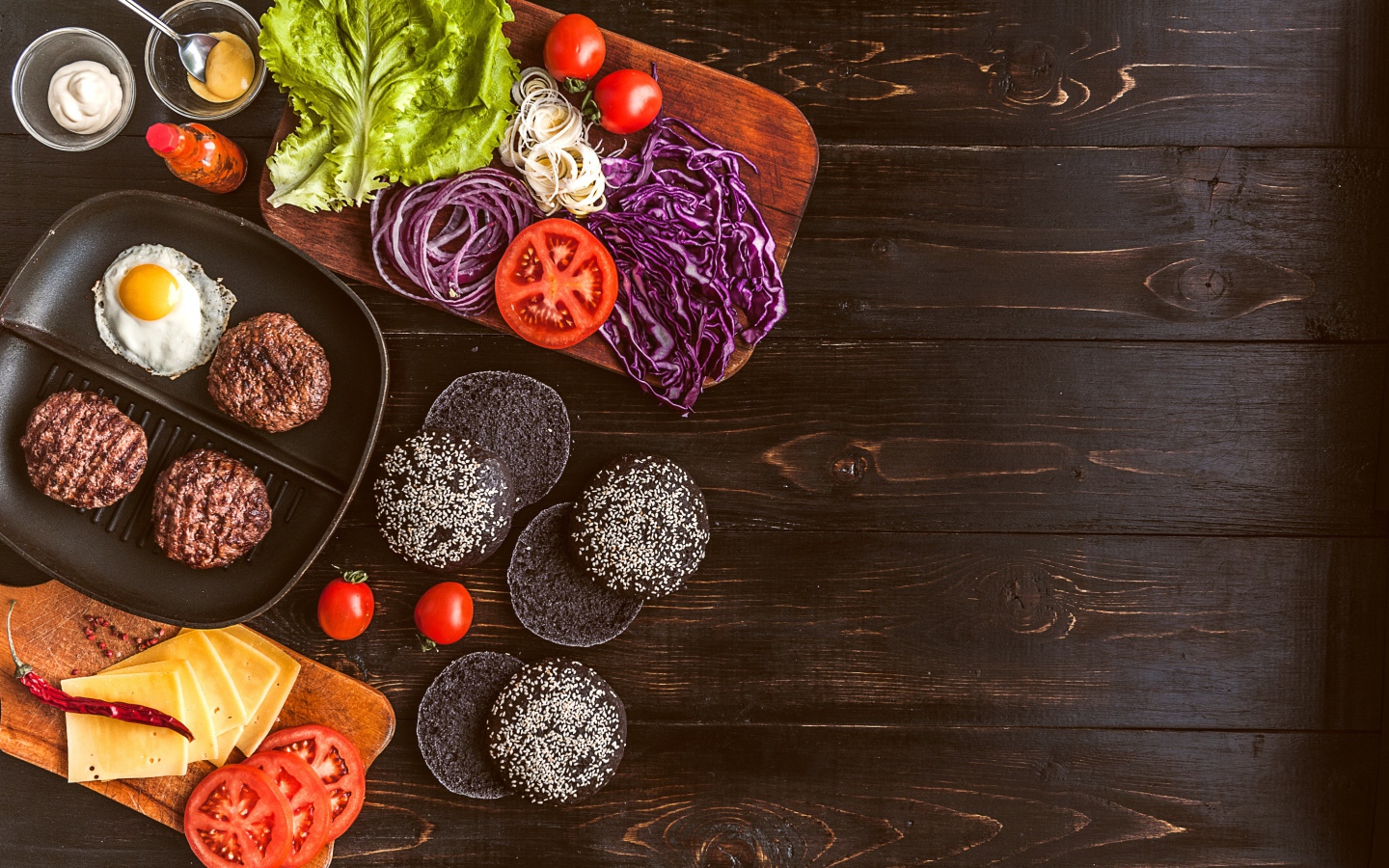 Повар готовит гамбургеры на деревянном столе