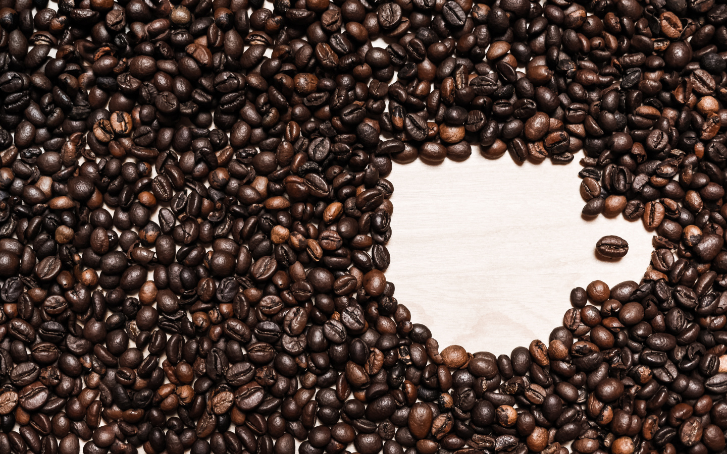 Рисунок чашки из кофейных зерен на столе