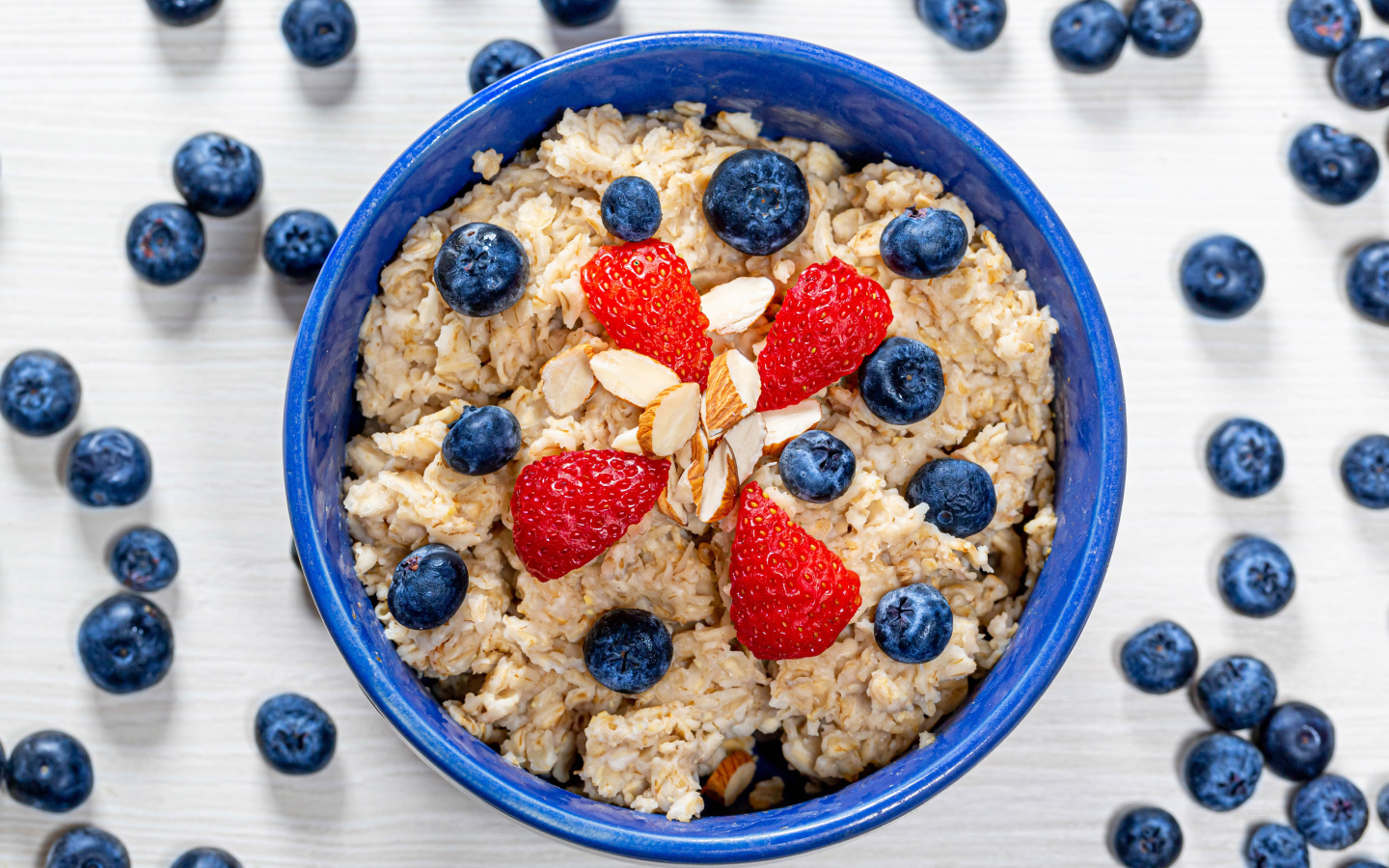 Овсяная каша в тарелке с ягодами черники и клубники 