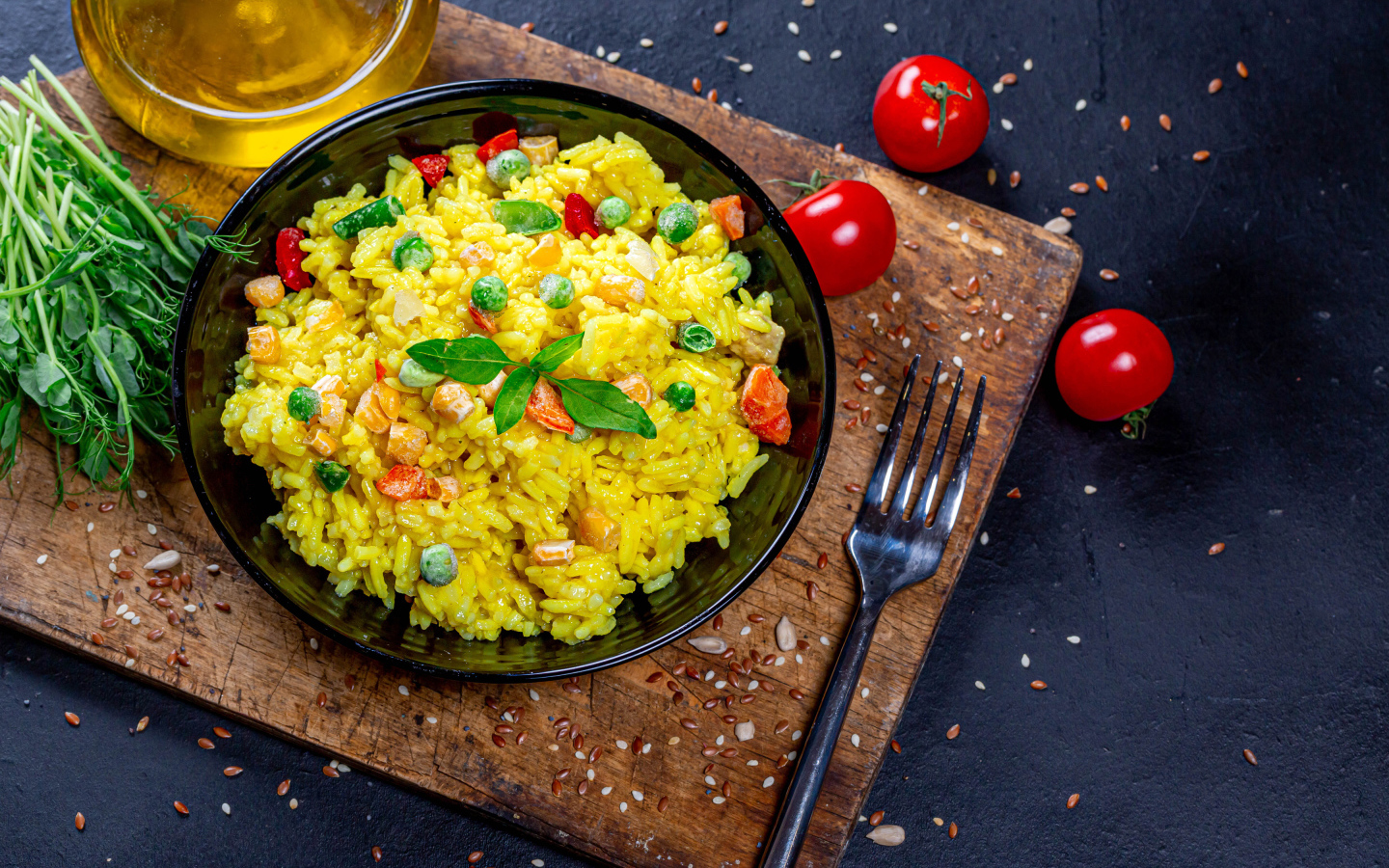 Рис с овощами на столе с маслом, зеленью и помидорами 