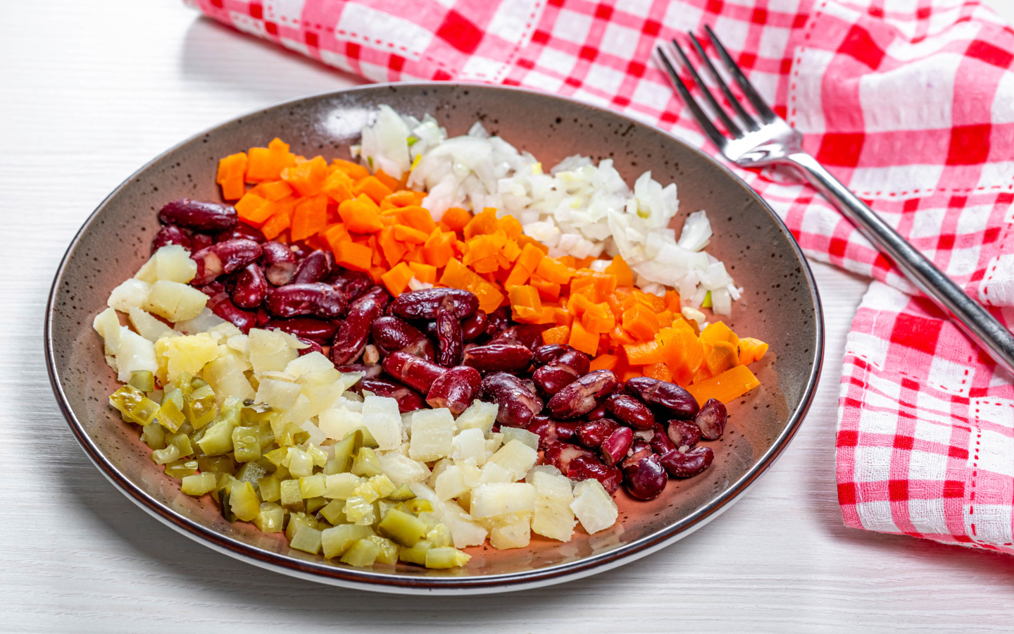 Овощи и фасоль нарезанные на тарелке 