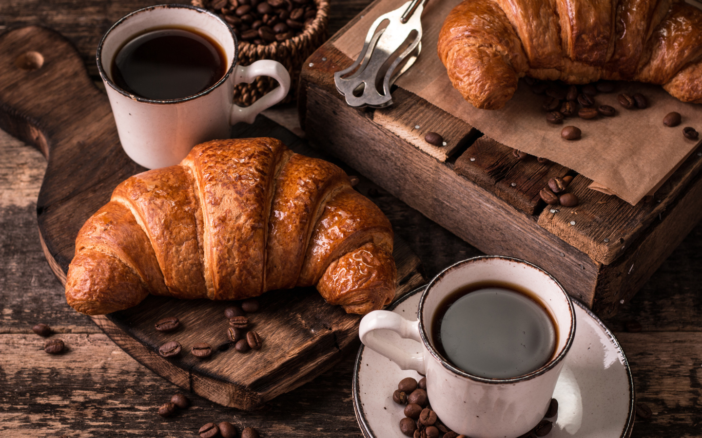 Две чашки кофе на столе с рогаликами и зернами 