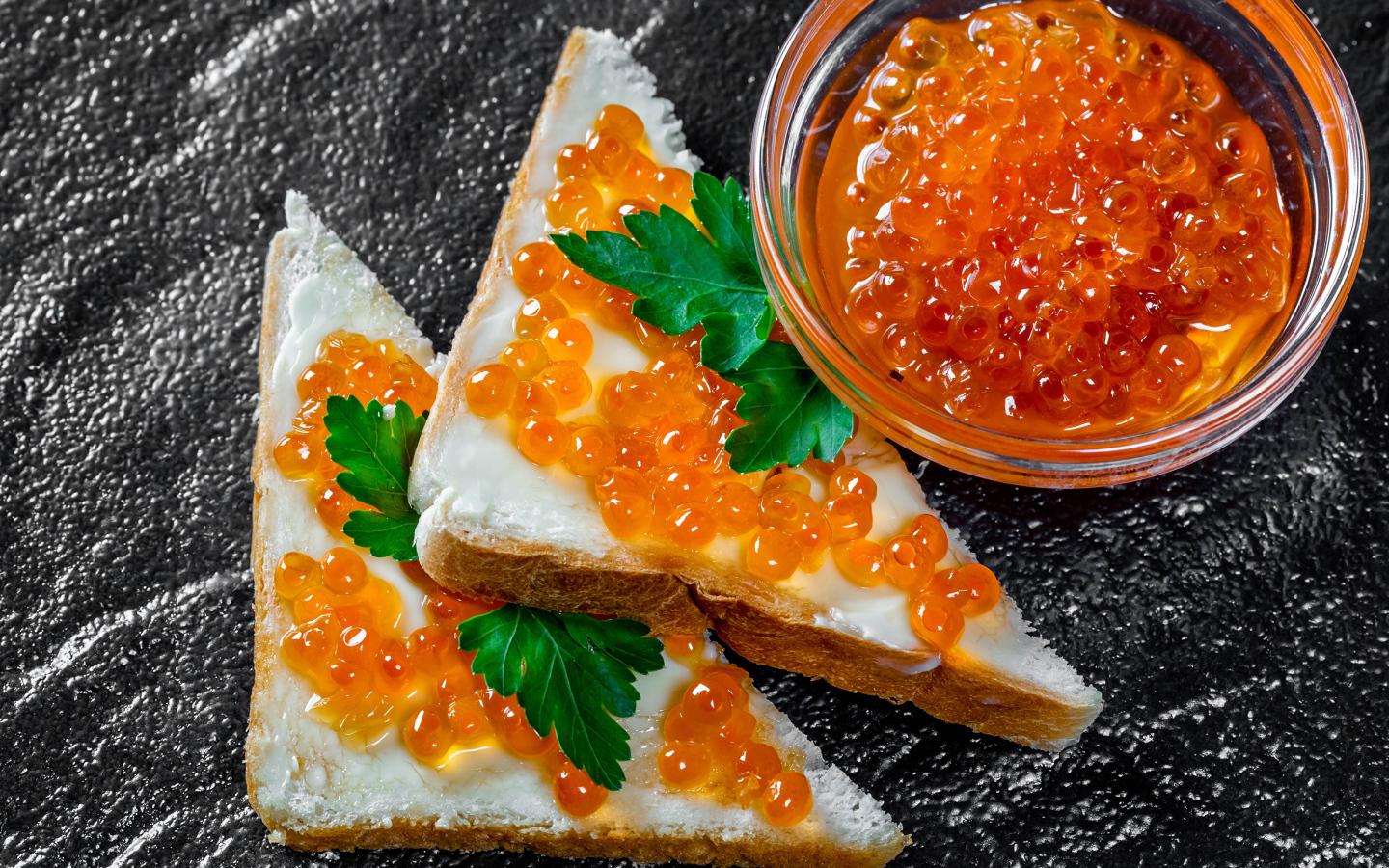 Два бутерброда с красной икрой на столе