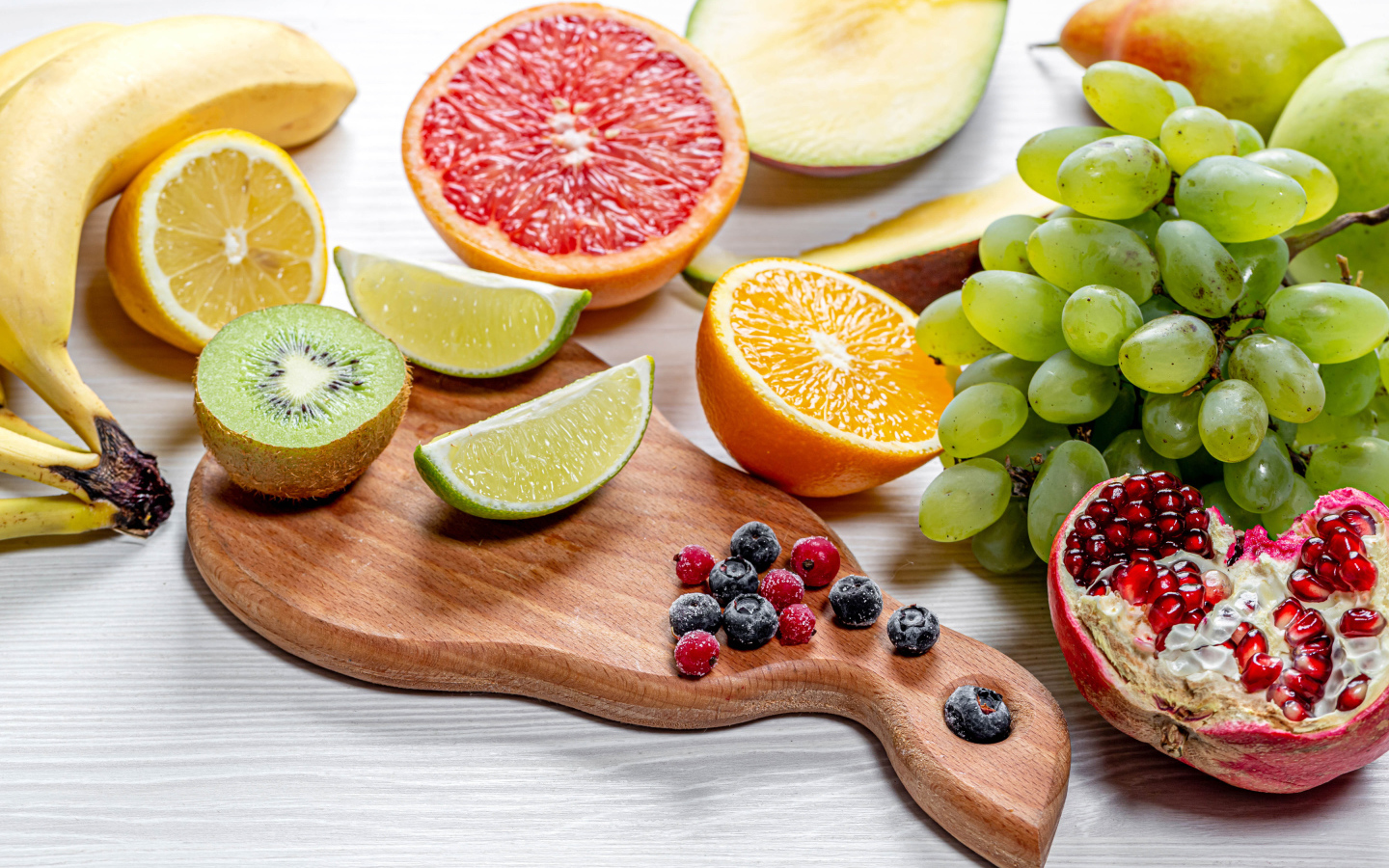 Вкусные цитрусовые фрукты и виноград на столе