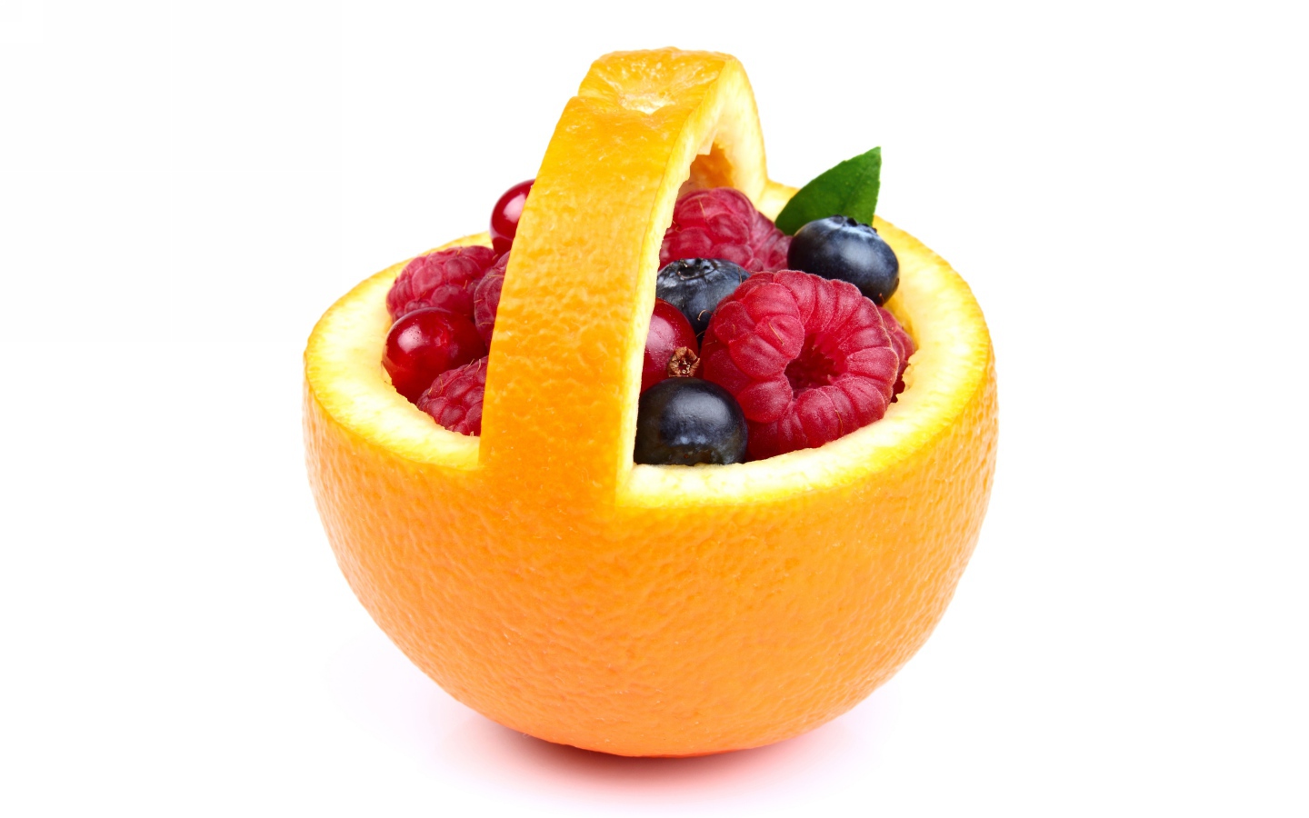 Свежие ягоды в кожуре апельсина на белом фоне