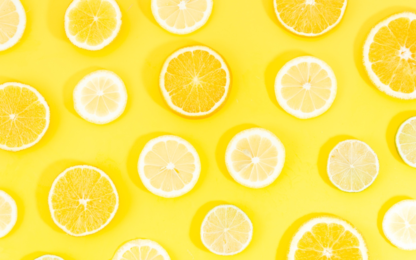 Кружочки апельсина и лимона на желтом фоне