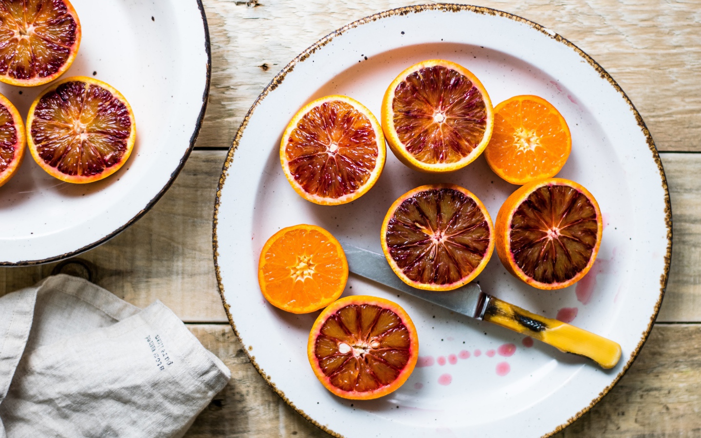 Половинки апельсина на тарелке с ножом