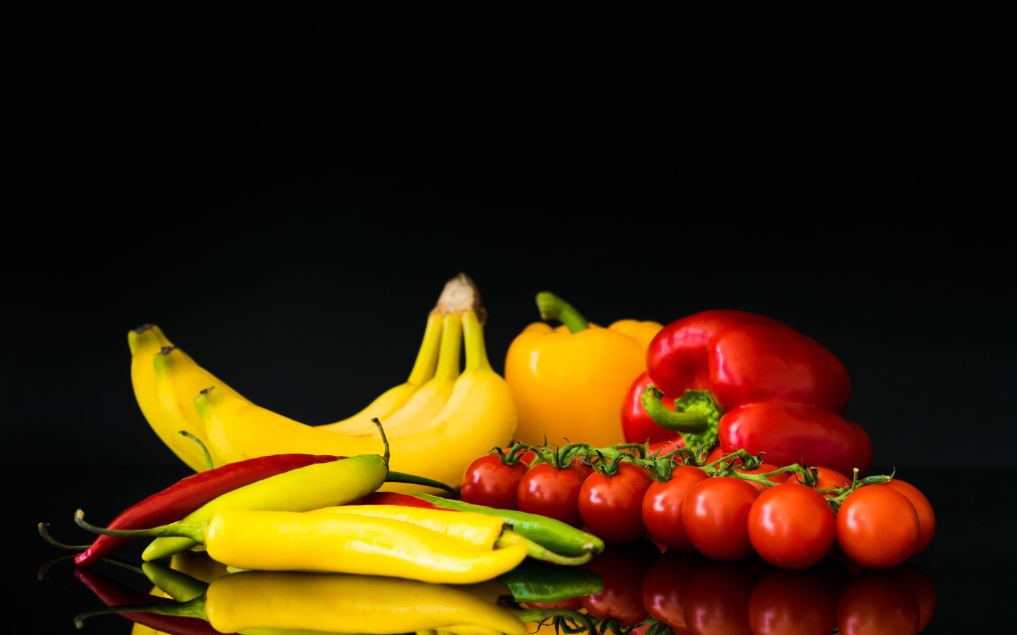 Перец, помидоры и бананы на черном фоне