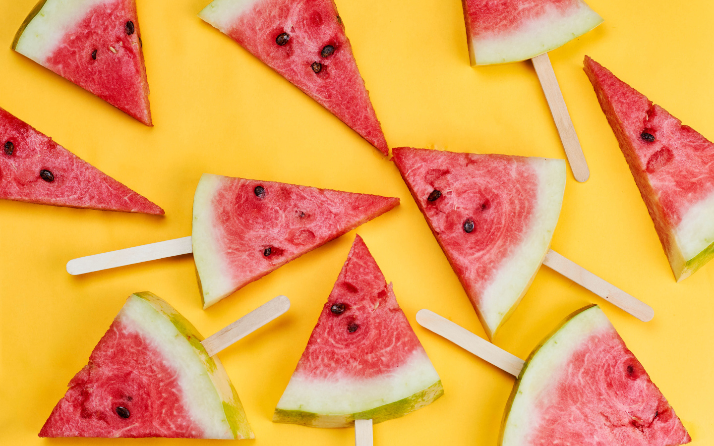 Кусочки арбуза на палочках на желтом фоне