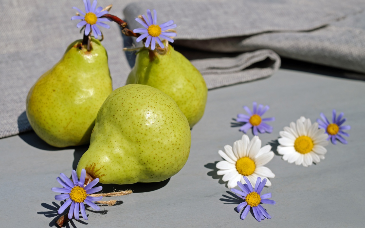Три груши на столе с цветами