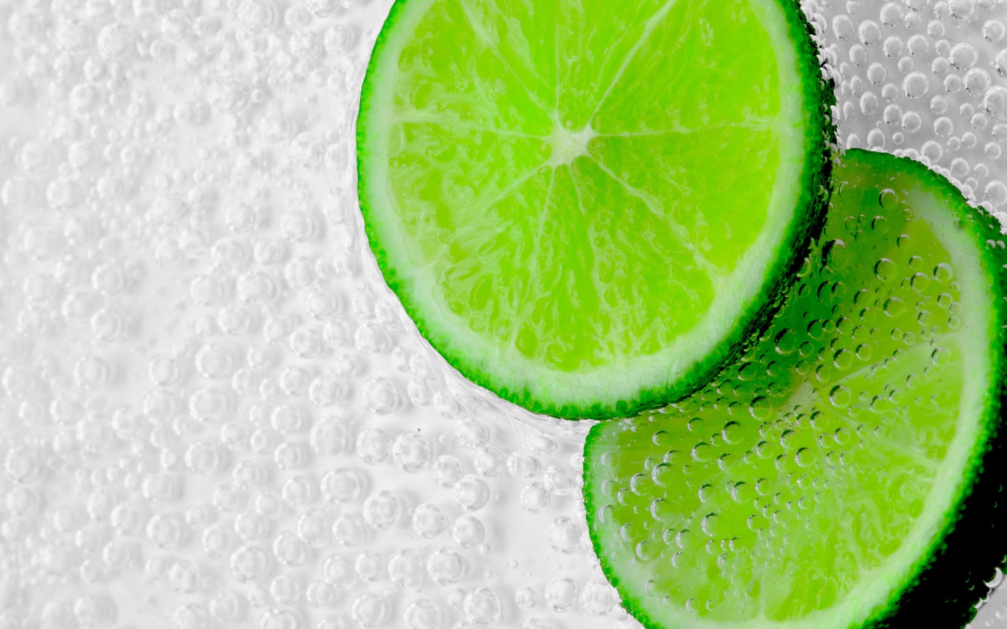 Два куска лайма в пузырях в воде 