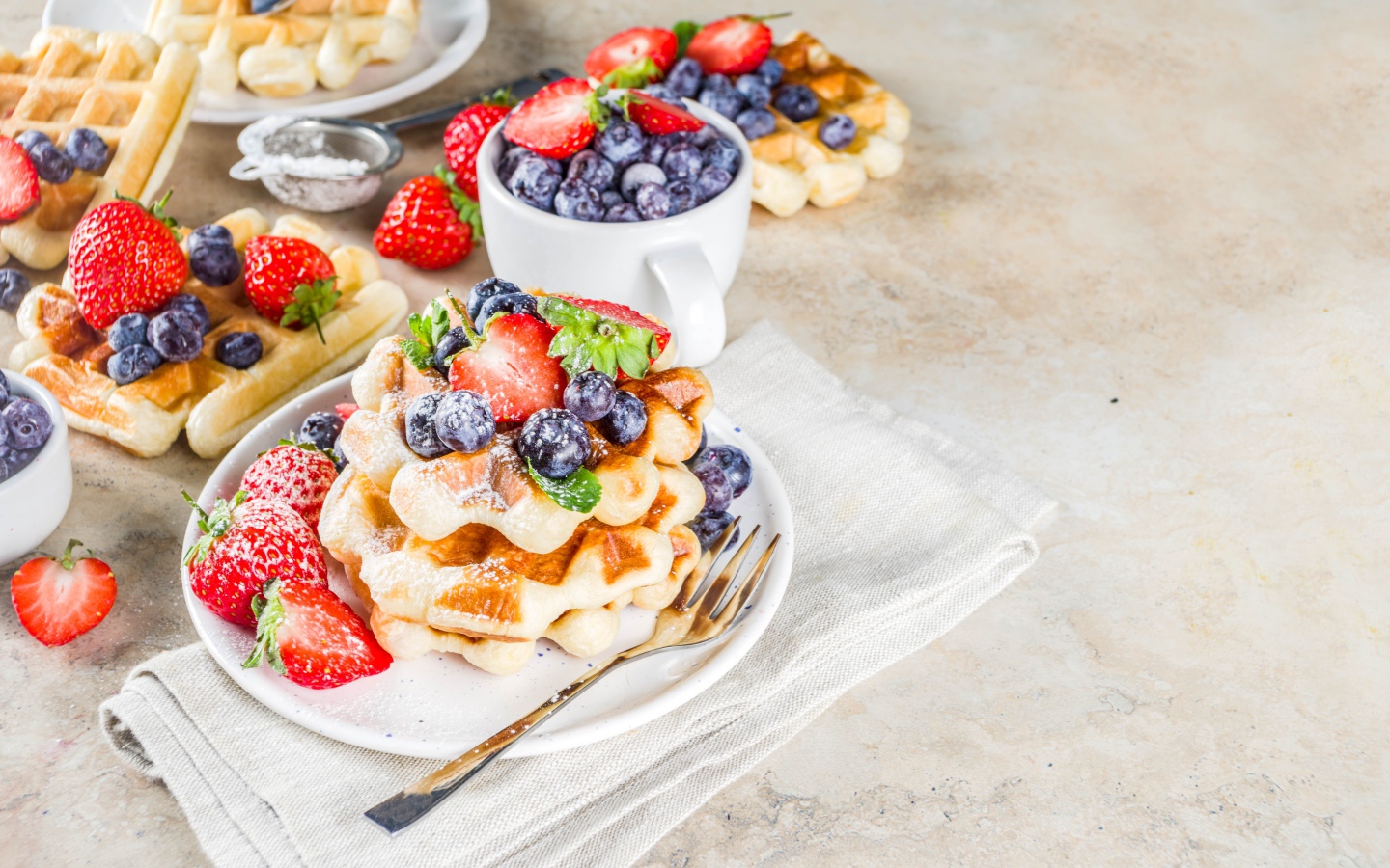 Вкусные сладкие вафли на тарелке с ягодами и сахарной пудрой 