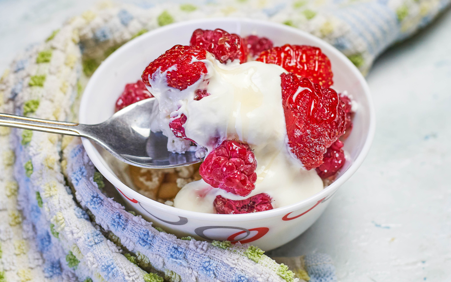 Завтрак с йогуртом и малиной в миске с ложкой