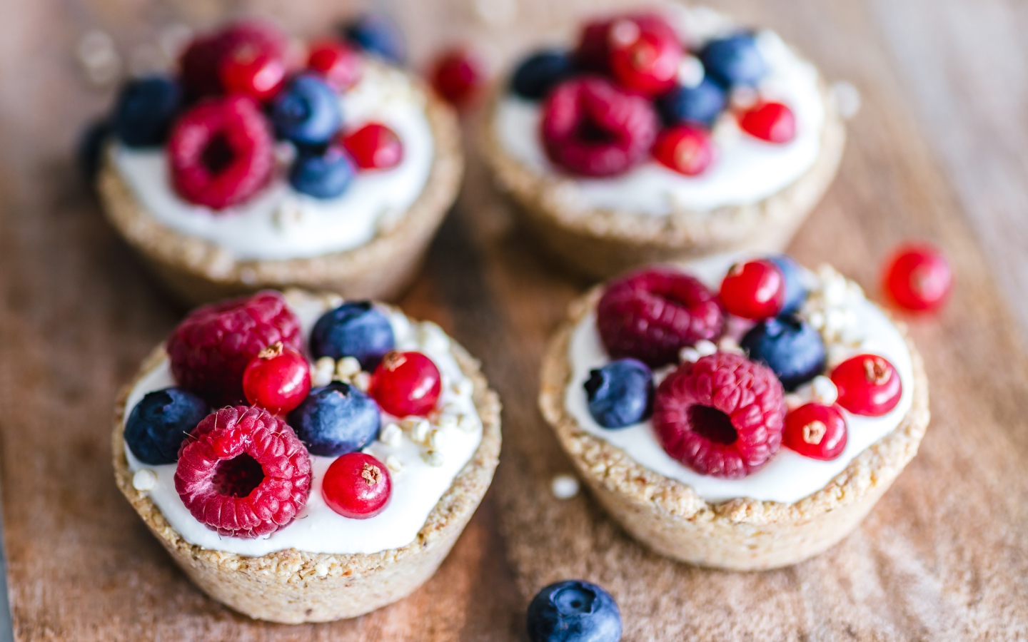 Пирожные с кремом и ягодами на столе крупным планом