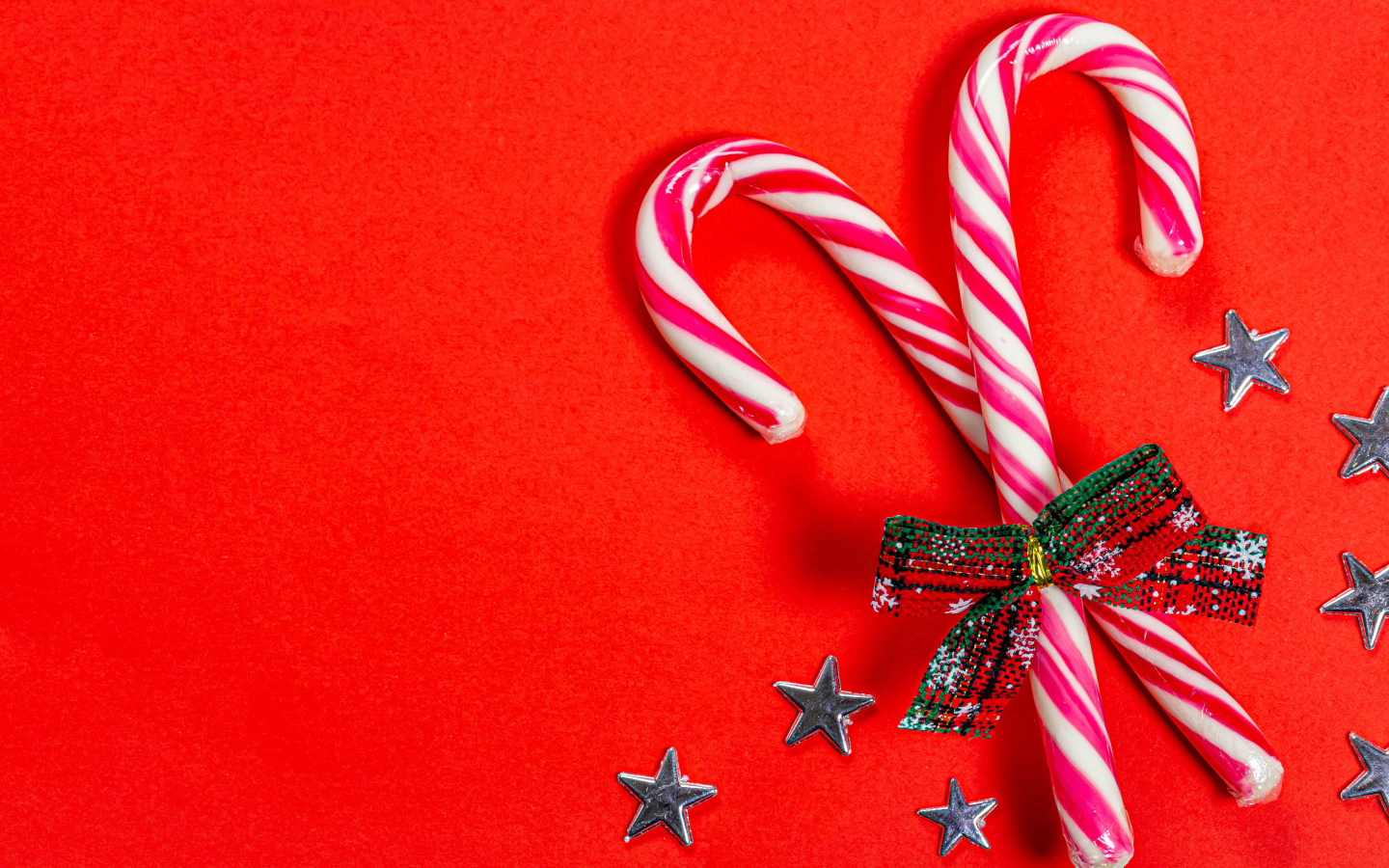 Рождественские леденцы с бантом на красном фоне