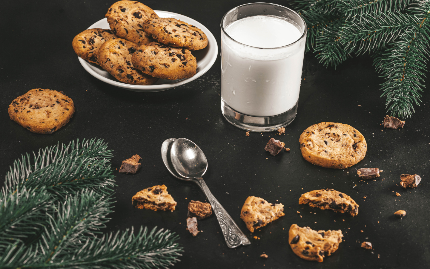 Печенье на столе с молоком и еловыми ветками