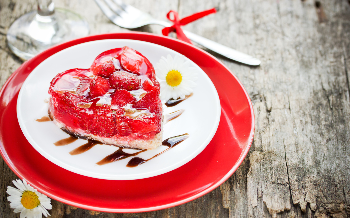 Пирожное с клубникой в форме сердца на тарелке с ромашками