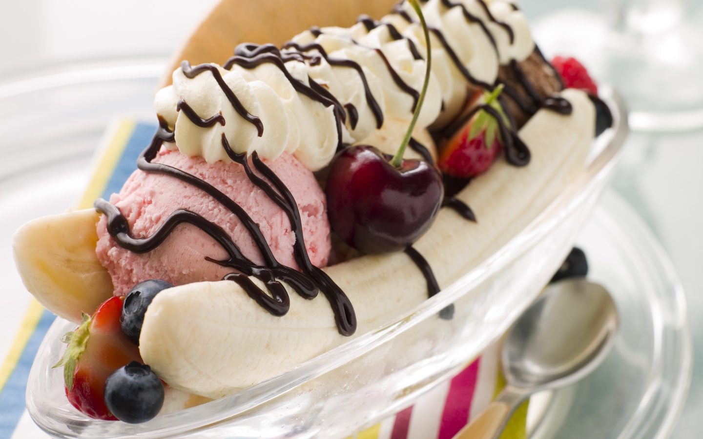 Шарики мороженого на тарелке с бананами и черешней 