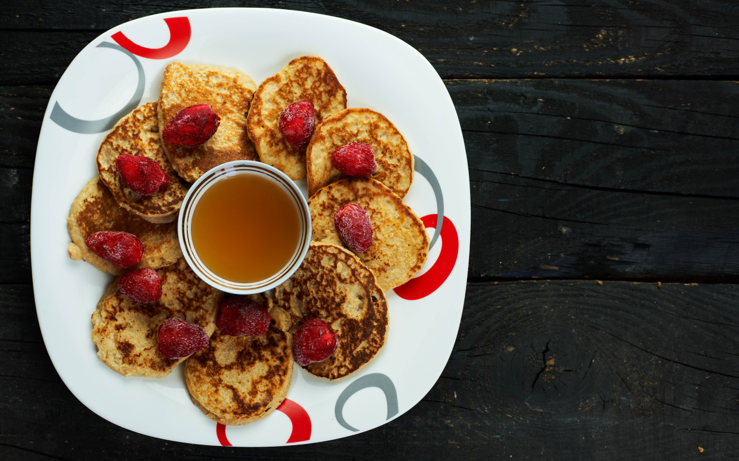 Оладьи на тарелке с клубникой и медом