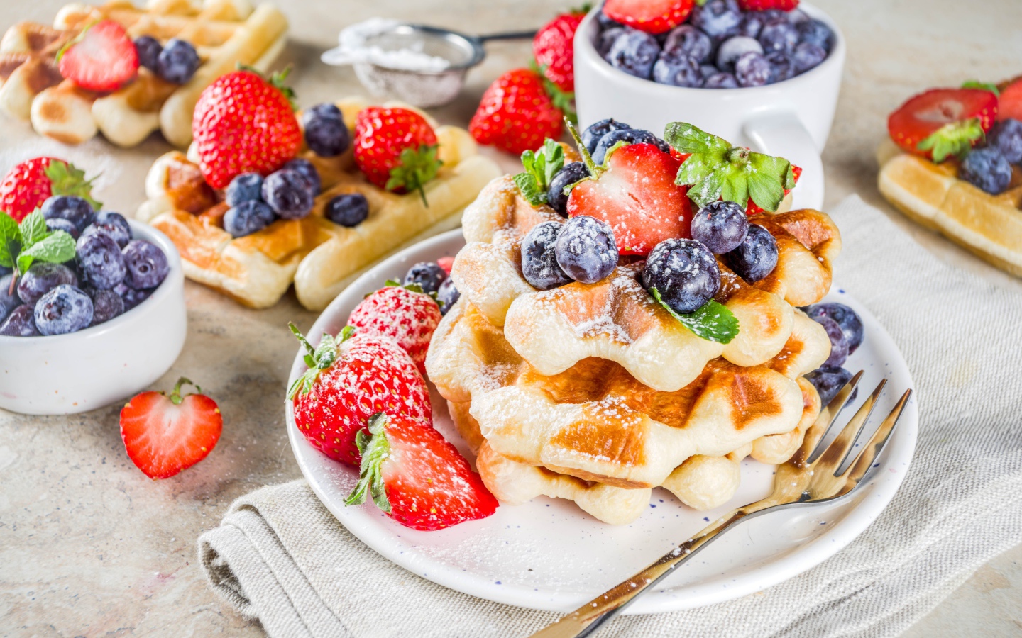 Вкусные сладкие вафли с ягодами клубники, черники и сахарной пудрой