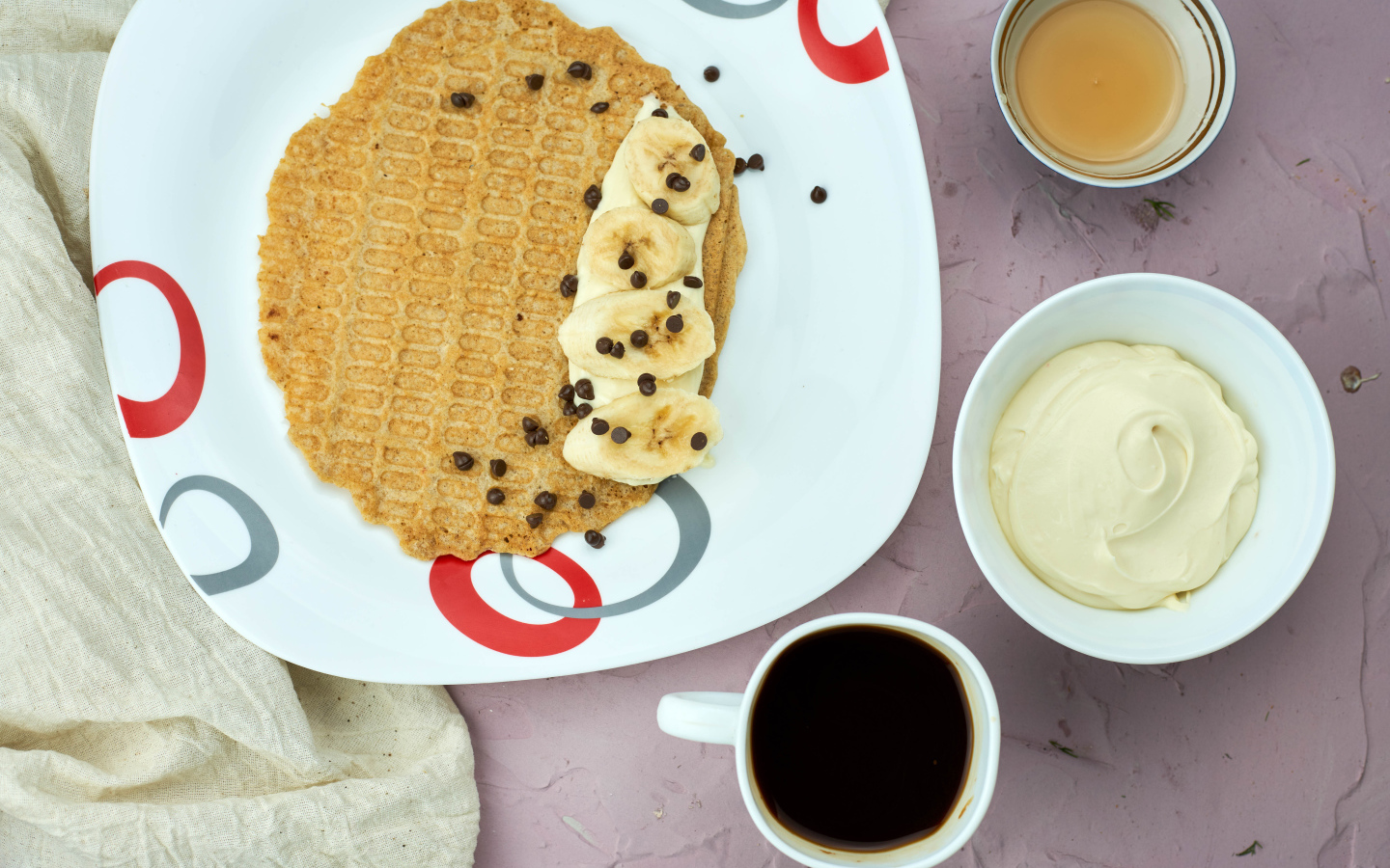 Вафля с бананами на столе с кофе и сметаной 